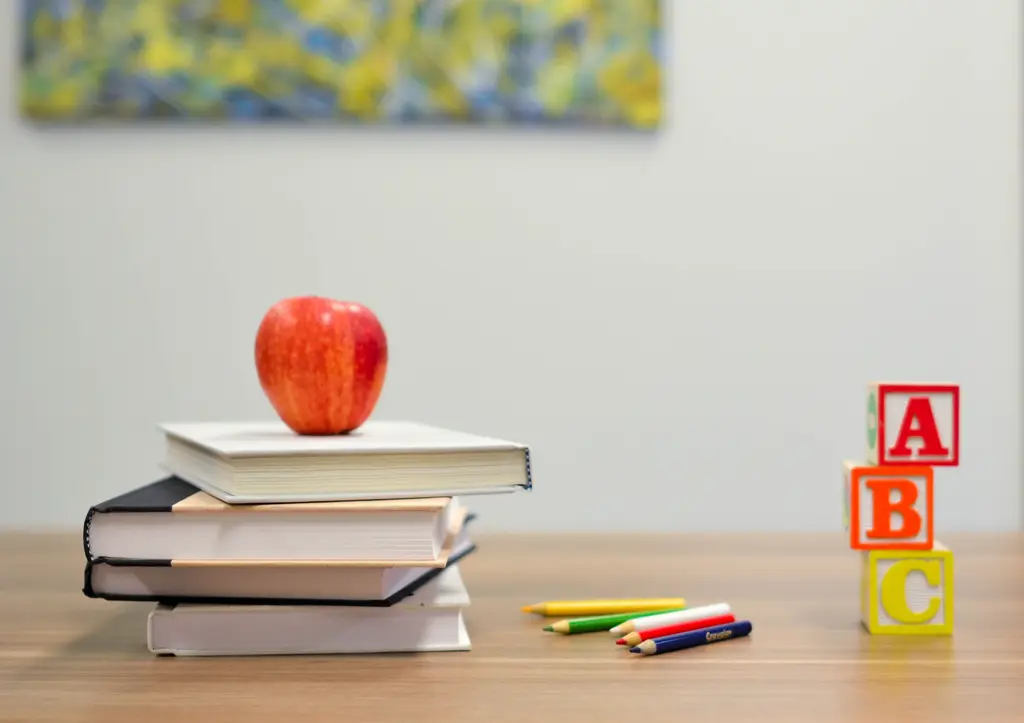 blogerski rečnik kockice sa slovima, olovke i knjige sa jabukom